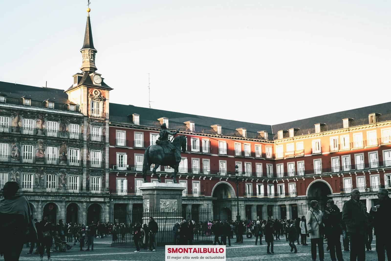 A lively scene at Plaza Mayor, Madrid, featuring historic architecture and a statue.